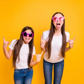 Selbstbestimmt leben: Zwei selbstbewusste Mädchen strecken die Zunge heraus